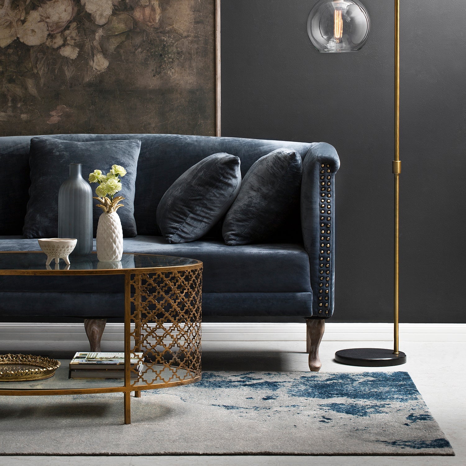 Loft Home Sofas by Space Collection - Elegant navy velvet sofa with studded detailing, paired with a gold geometric coffee table and modern decor in a sophisticated dark interior