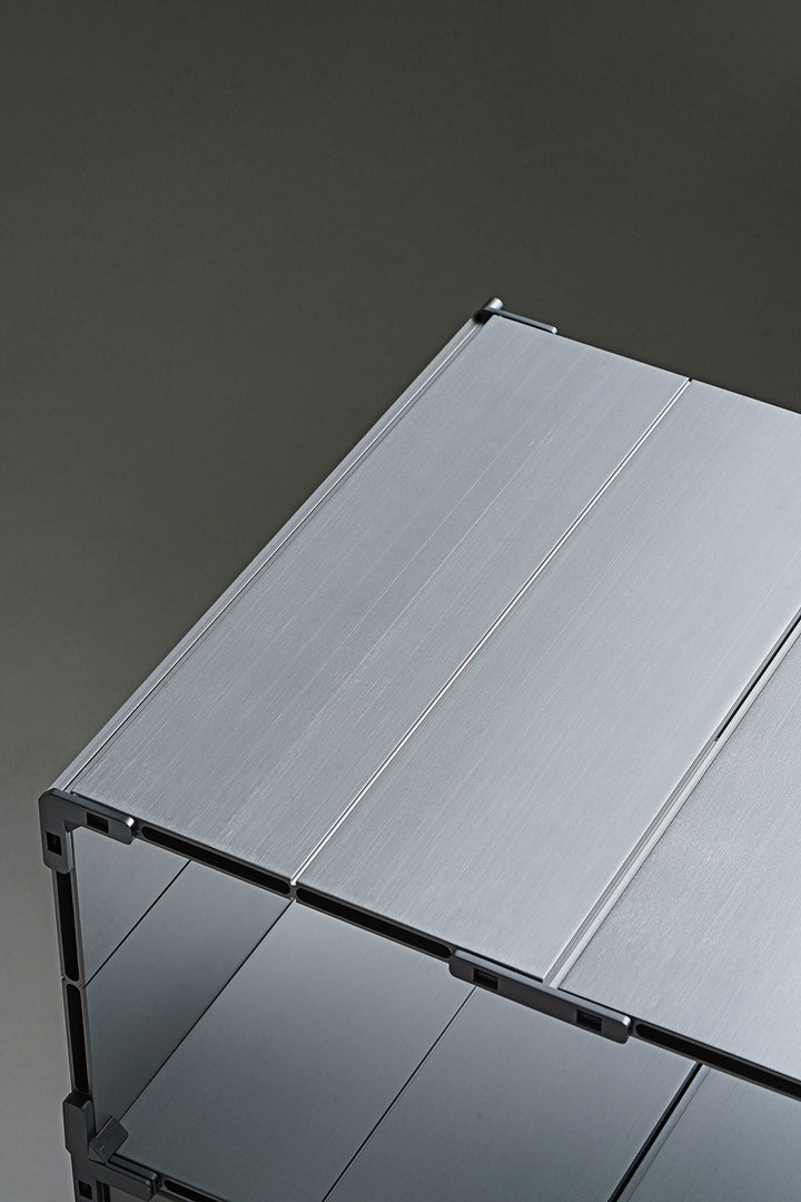 Aluminum metal table on a dark gray background, showcasing loft home Singapore's featured products for metal tables.