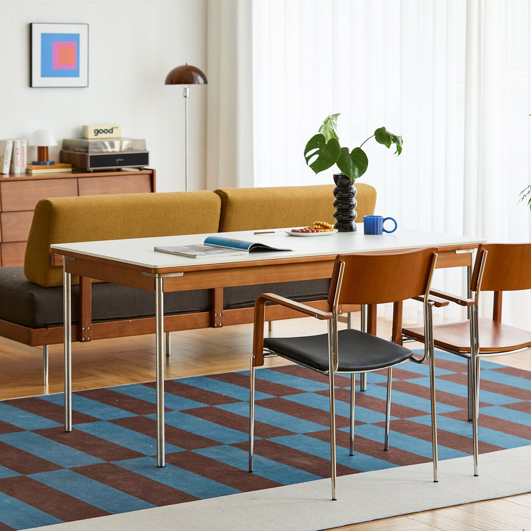 Contemporary wooden dining table with sleek chairs, styled in a bright modern interior, showcasing versatile clearance furniture for Singapore homes.