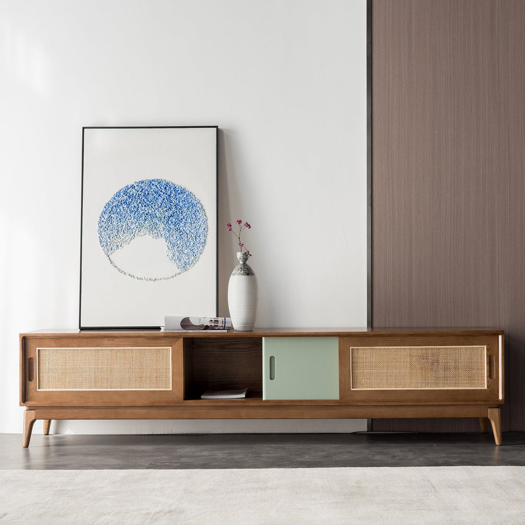 Walnut TV console featuring cane sliding doors and a green accent panel, blending vintage charm with modern functionality, perfect for eclectic living spaces.