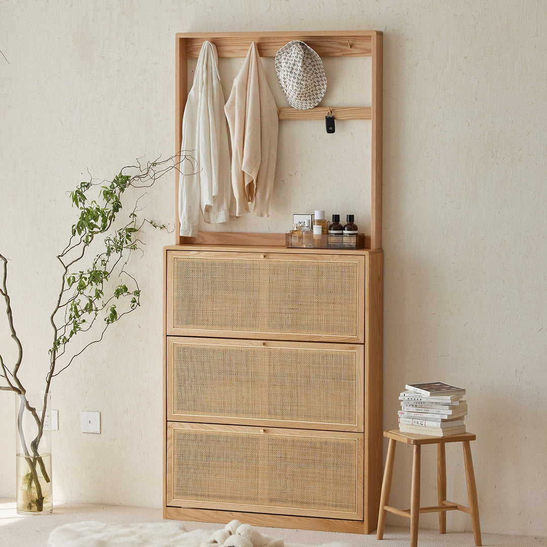 Wooden clothes hanger with a built-in shelf and cane-weaved drawers, ideal for organizing garments, accessories, and daily essentials in a minimalist interior.