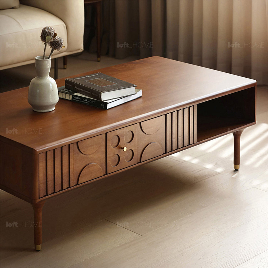 Mid-century modern wooden coffee table with artistic carved details, spacious storage compartments, and elegant tapered legs for timeless charm.