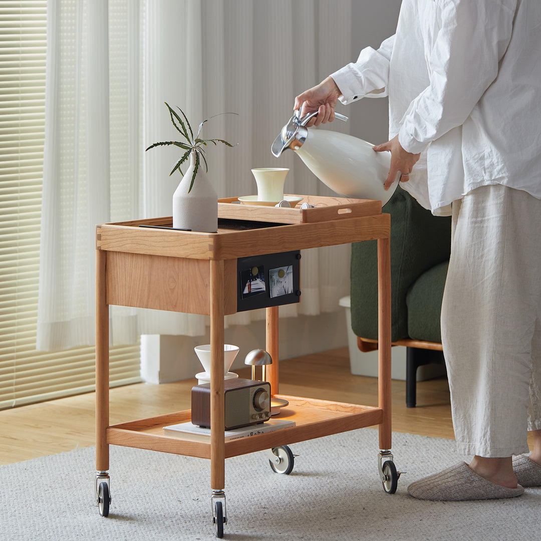 Scandinavian cherry wood wheeled trolley side table pocket in panoramic view.