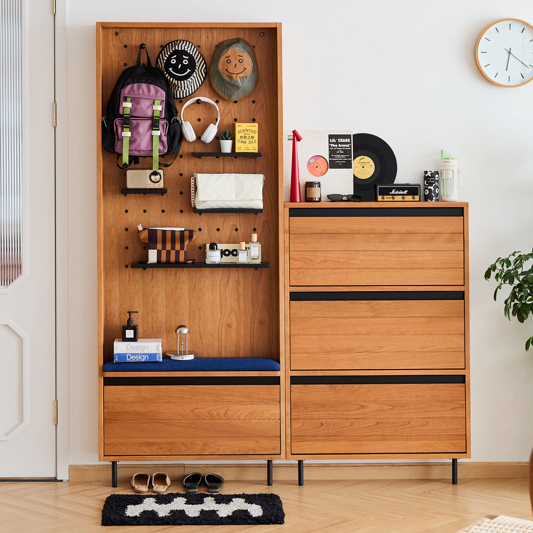 Scandinavian cherry wood shoe cabinet corner in still life.