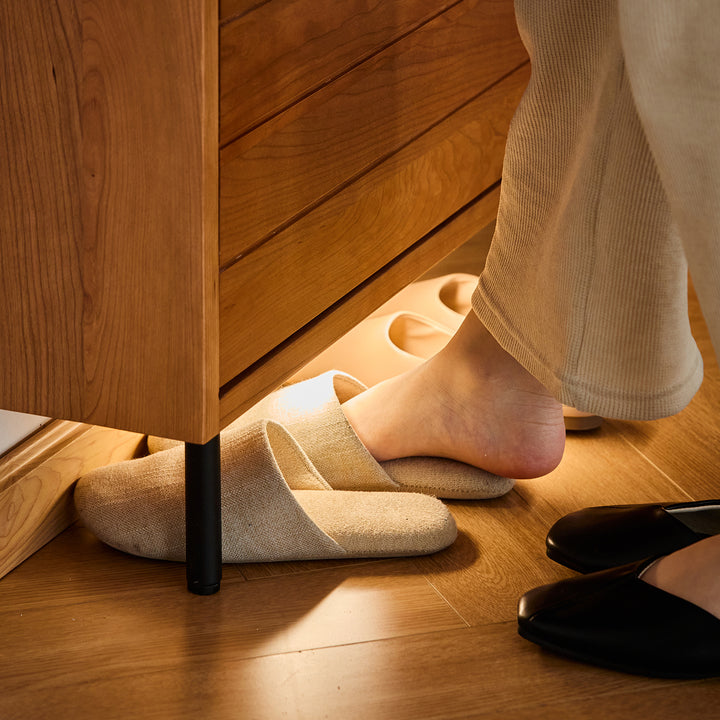 Scandinavian cherry wood shoe cabinet corner in real life style.