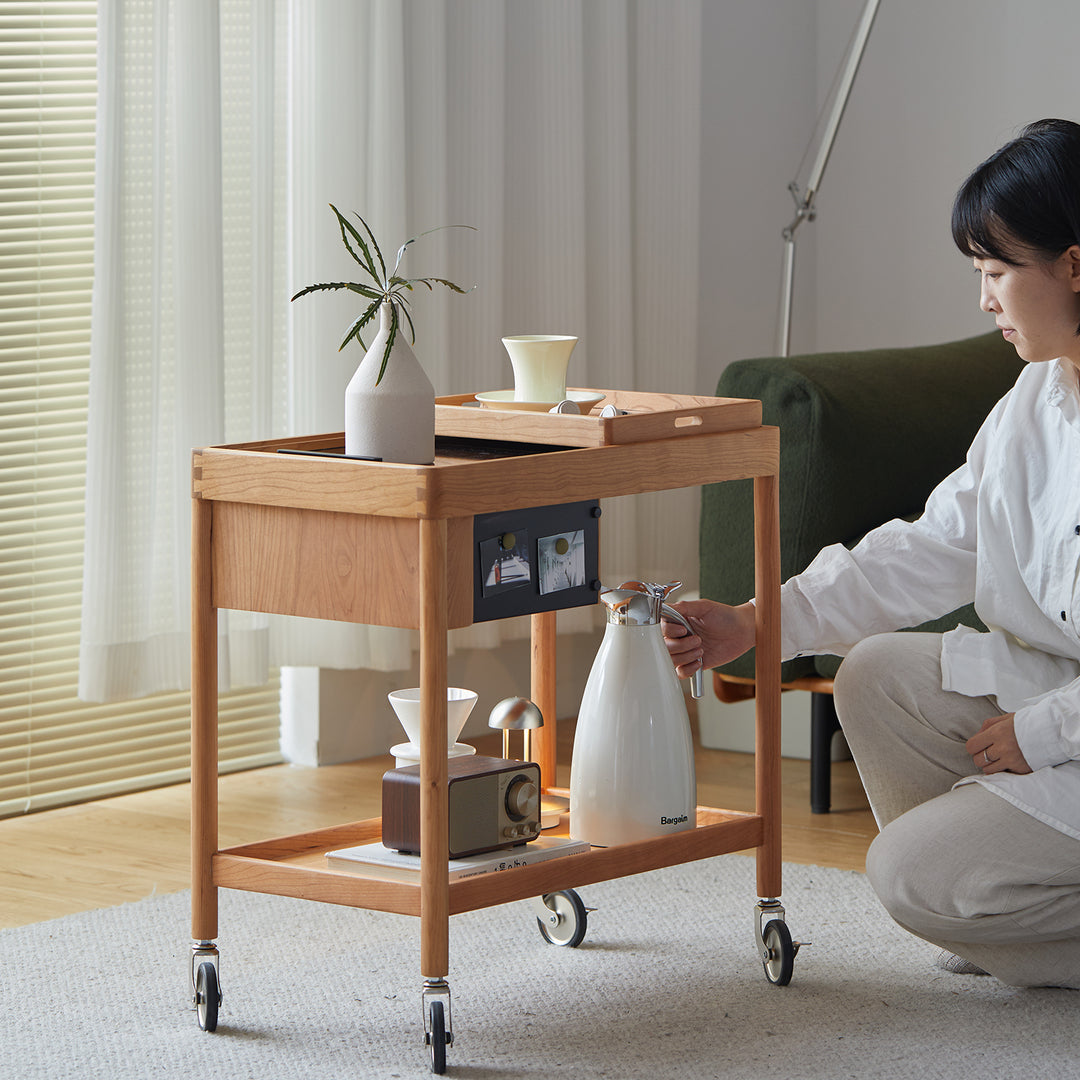 Scandinavian cherry wood wheeled trolley side table pocket in close up details.