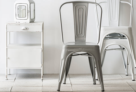 Minimalist room with metal chairs and a white cabinet. Explore the chair collection at Loft Home Furniture.