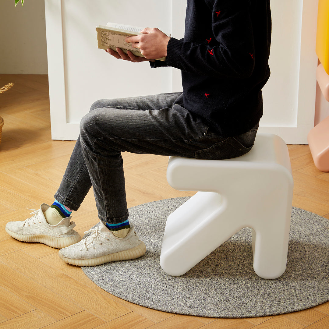 Contemporary plastic stool side table arrow in still life.