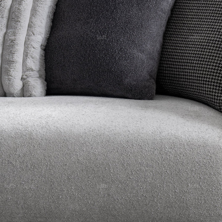 Minimalist boucle fabric bendable armrest 4.5 seater sofa pristine in still life.