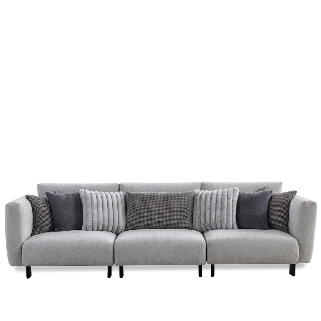 Minimalist boucle fabric bendable armrest 4.5 seater sofa pristine in white background.