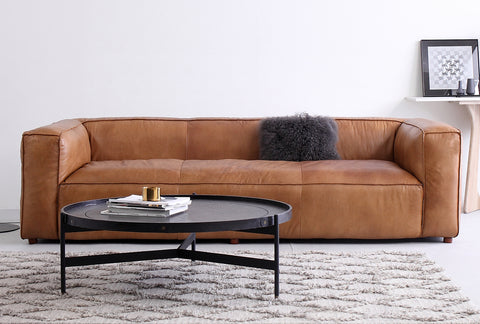 Modern living room with a sleek brown leather sofa, a stylish black coffee table, and minimalist decor, linking to Loft Home's regular sofa collection.