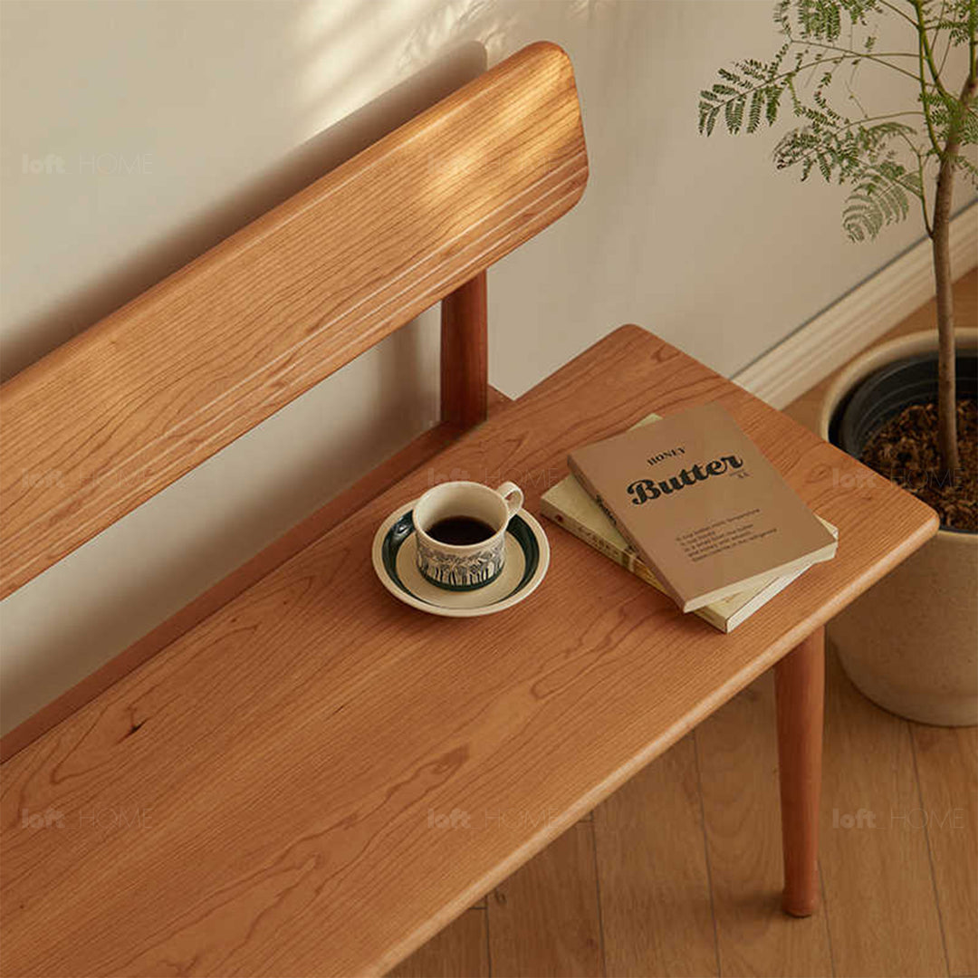 Scandinavian cherry wood cushion bench with backrest serene in real life style.