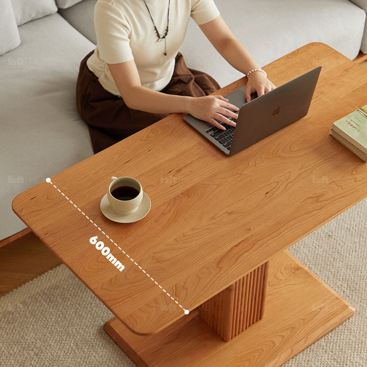 Scandinavian cherry wood height adjustable coffee table elevate in panoramic view.