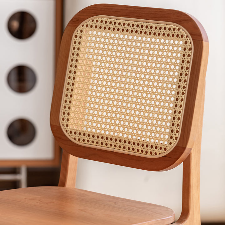 Scandinavian cherry wood rattan dining chair nook in panoramic view.