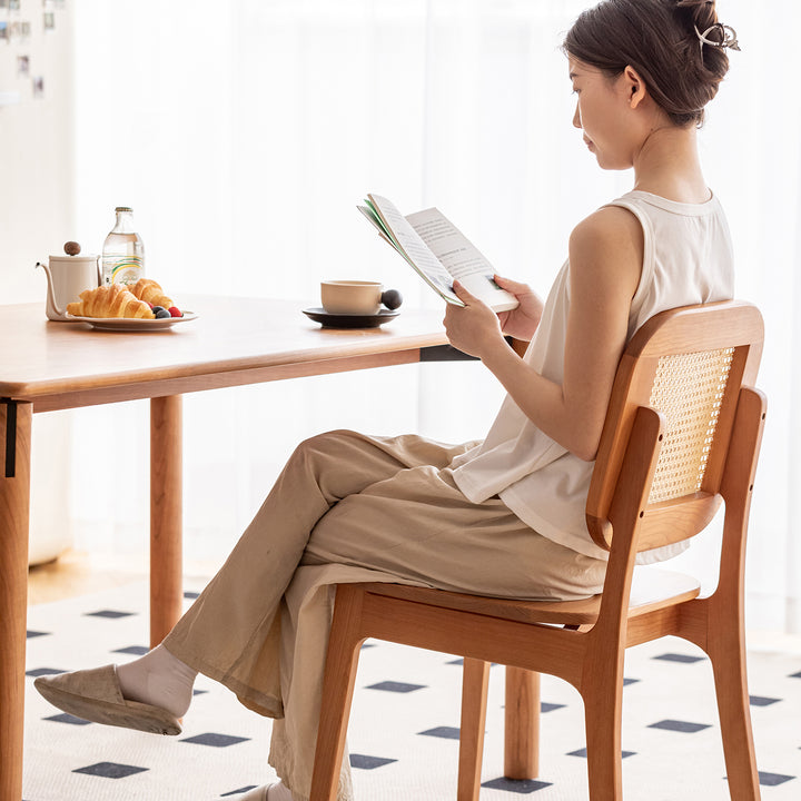 Scandinavian cherry wood rattan dining chair nook with context.
