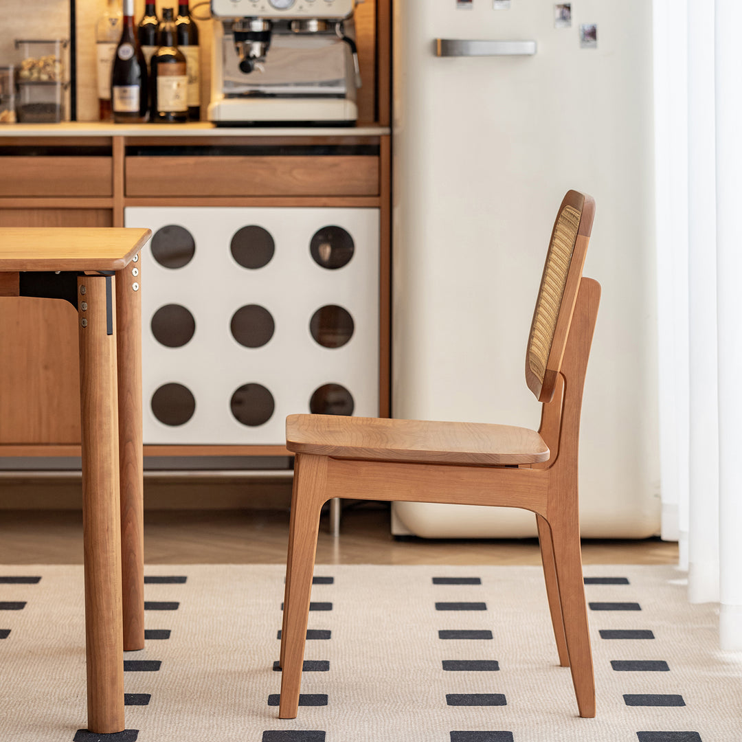 Scandinavian cherry wood rattan dining chair nook in close up details.