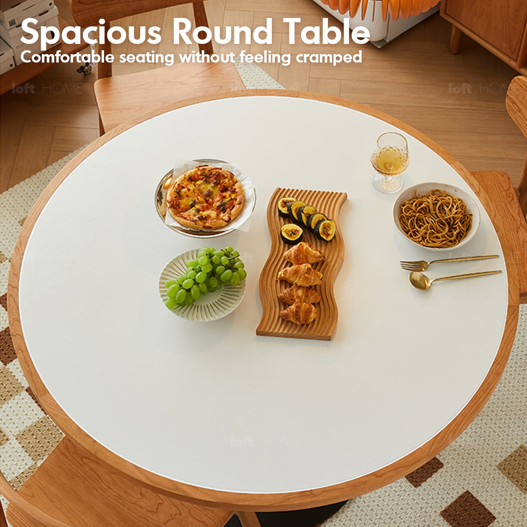 Scandinavian cherry wood sintered stone round dining table fusion in panoramic view.