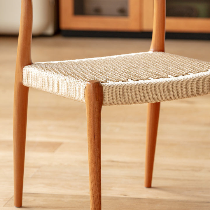 Scandinavian cherry wood woven rope dining chair autumn in panoramic view.