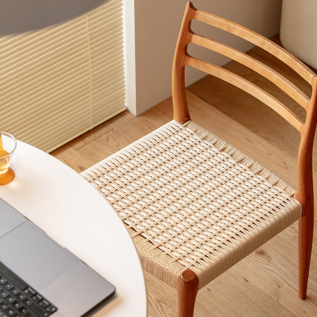 Scandinavian cherry wood woven rope dining chair autumn in close up details.