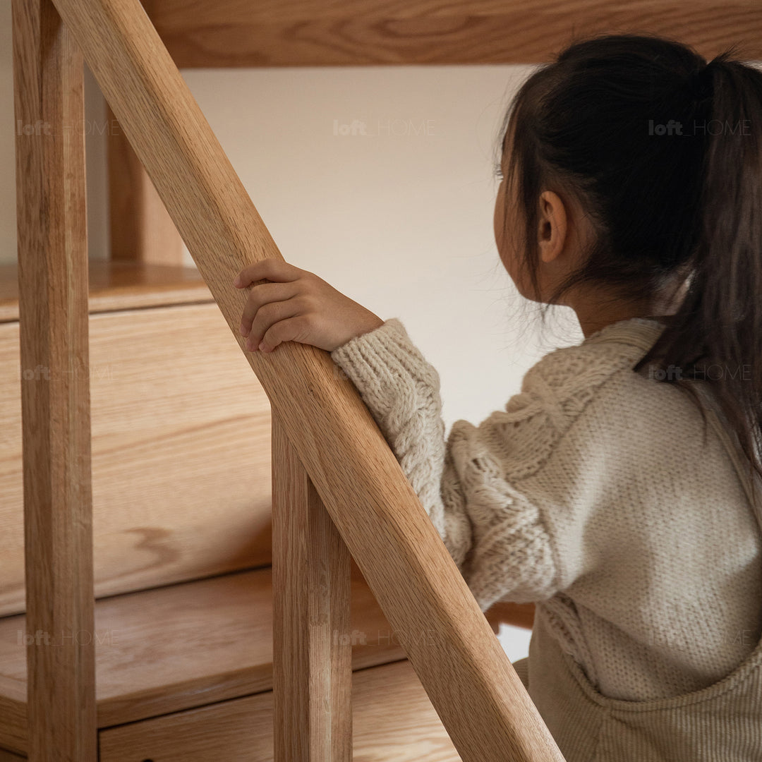 Scandinavian oak wood kids bunk bed with storage staircase and bottom drawers cloud in close up details.