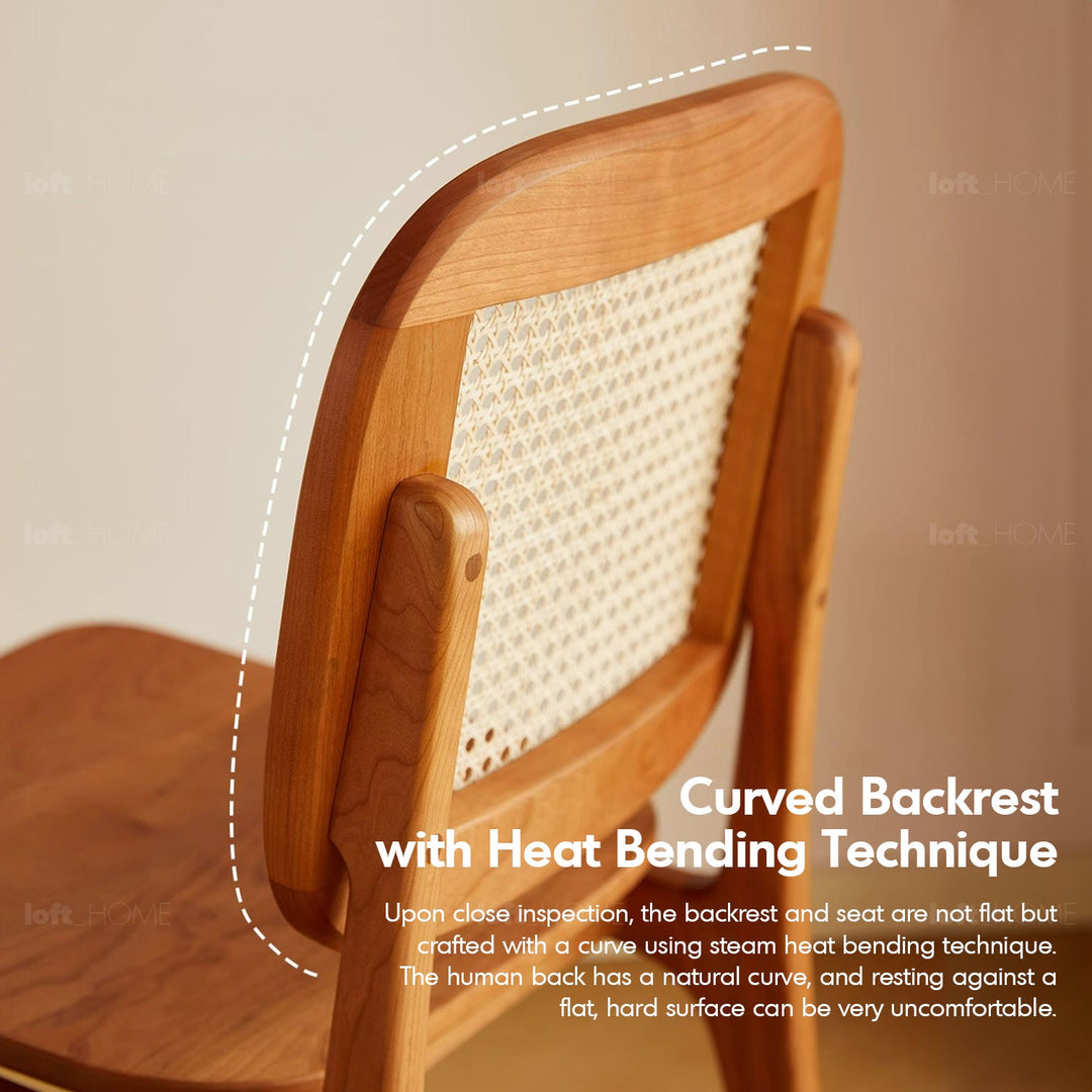 Scandinavian rattan cherry wood dining chair sor in close up details.