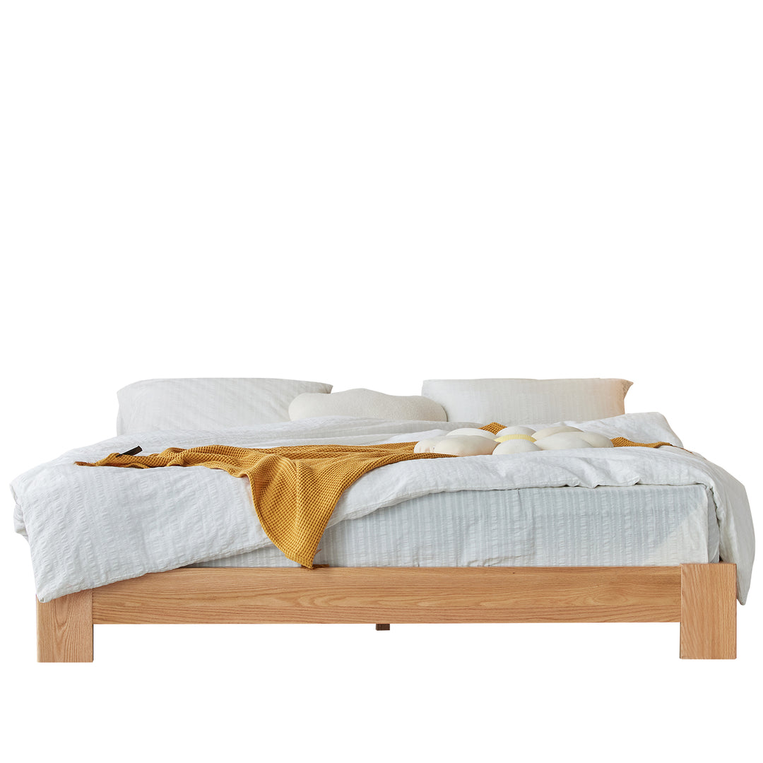 Scandinavian oak wood platform bed novella in white background.