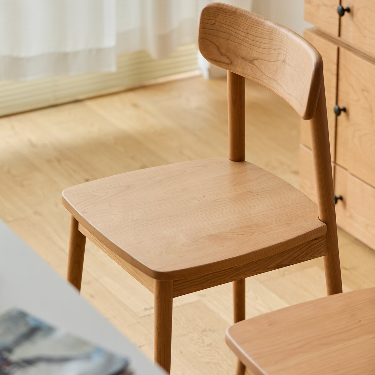 Scandinavian cherry wood dining chair green in panoramic view.