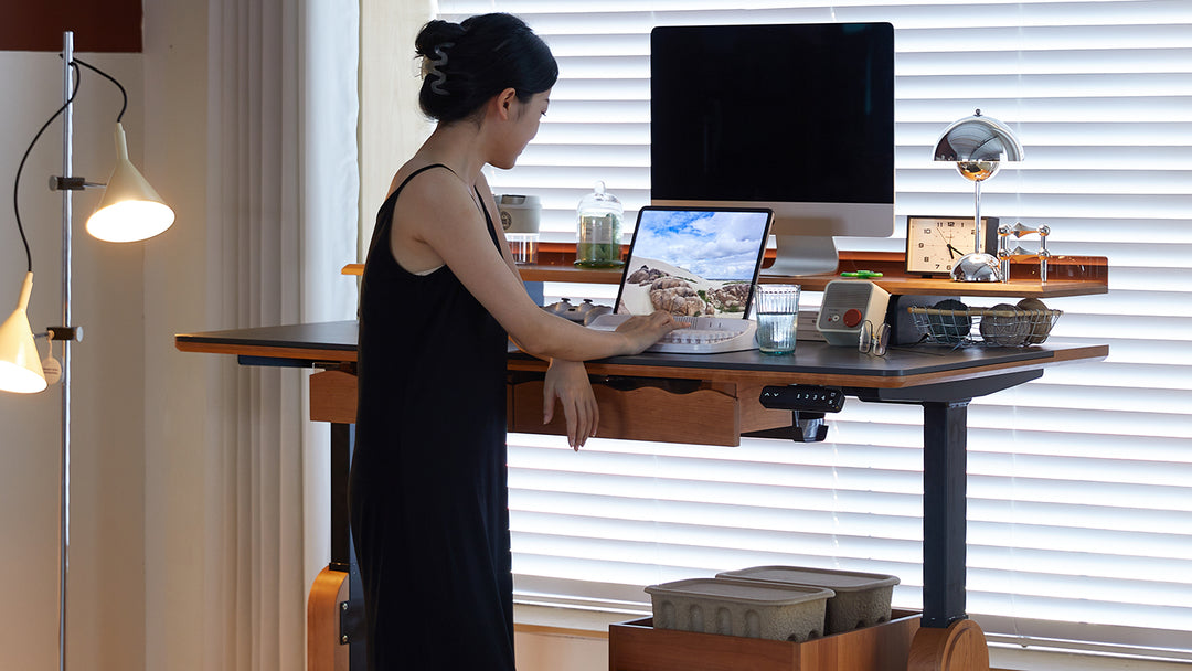 Loft Home adjustable desk featuring a woman working on a laptop in a stylish home office setting.