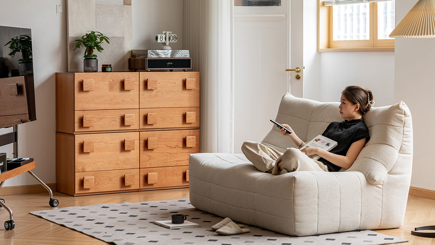Cozy modern living space with lounge chair, wooden storage drawers and soft textures, showcasing versatile furniture ideas for Singapore homes.
