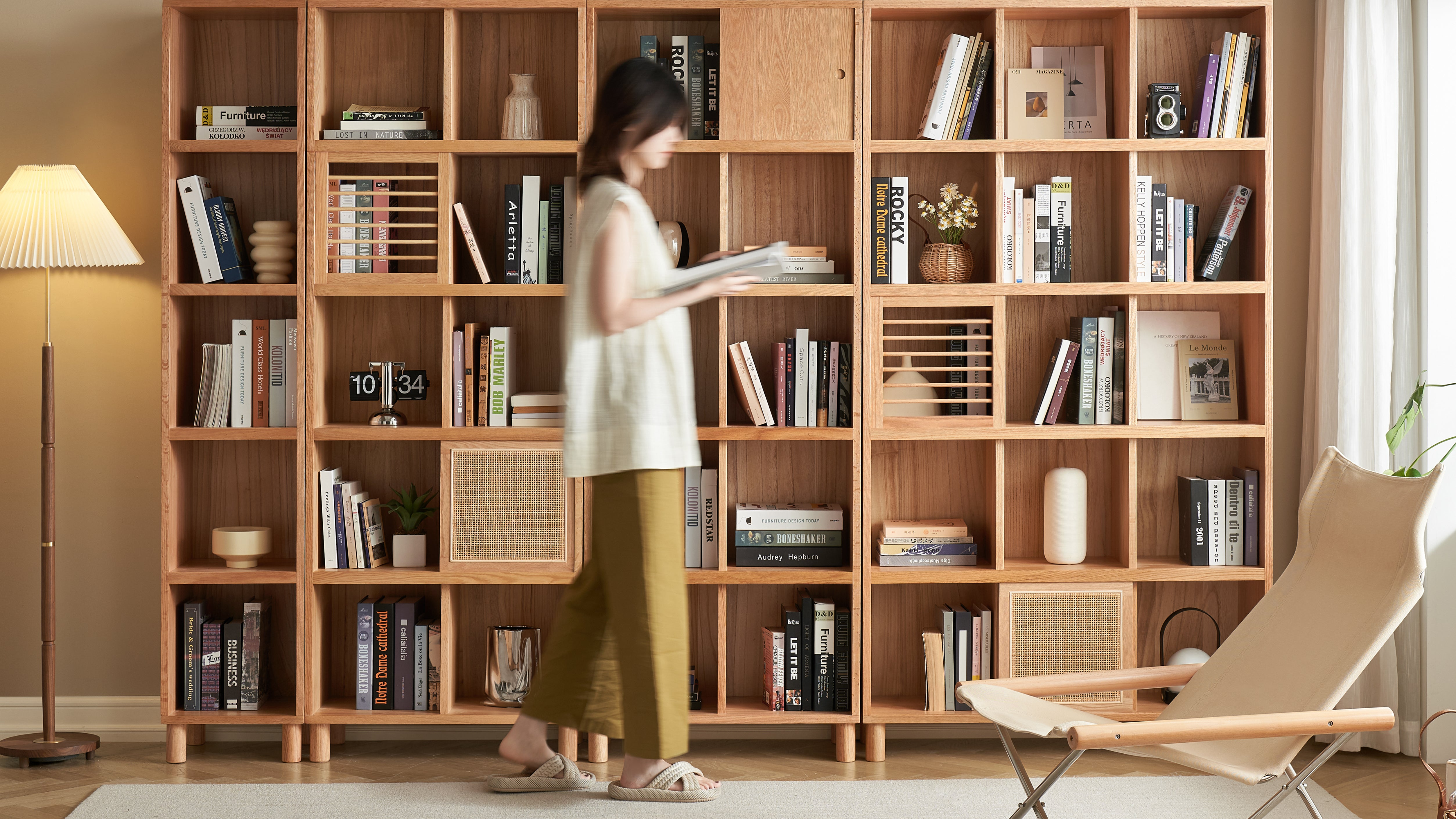 Loft Home modern bookshelf featuring a woman browsing books, with stylish wooden shelving and contemporary decor.