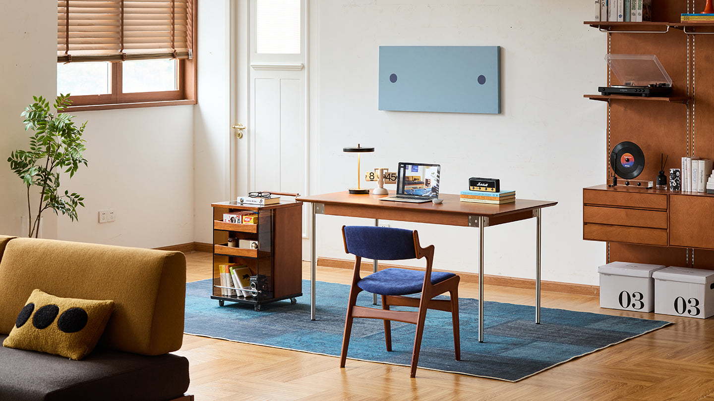 Modern living room with a desk, chair, and decorative items.