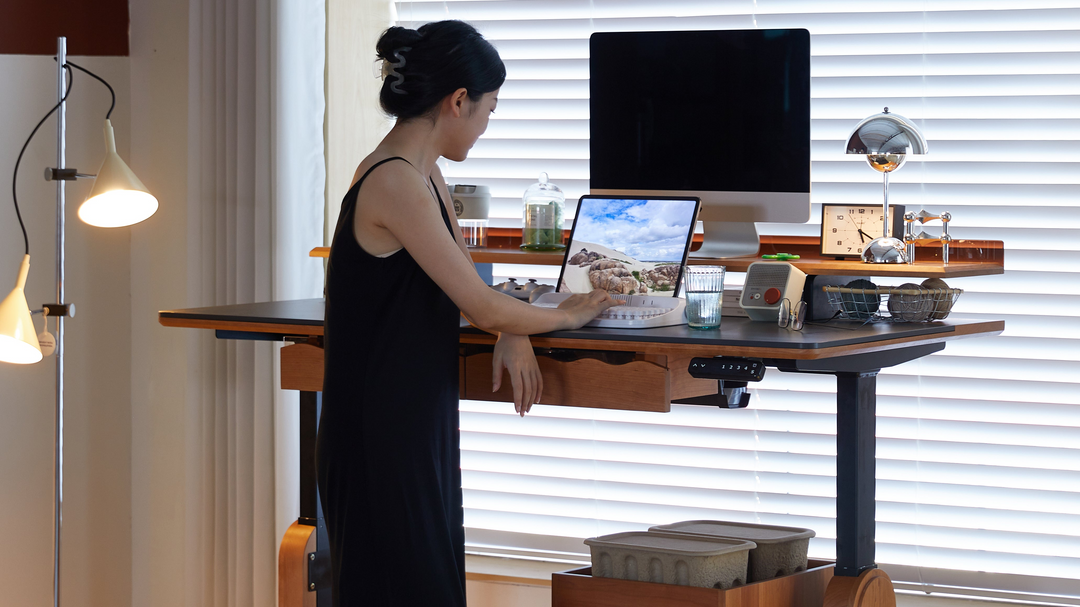 Loft Home adjustable desk featuring a woman working on a laptop in a stylish home office setting.