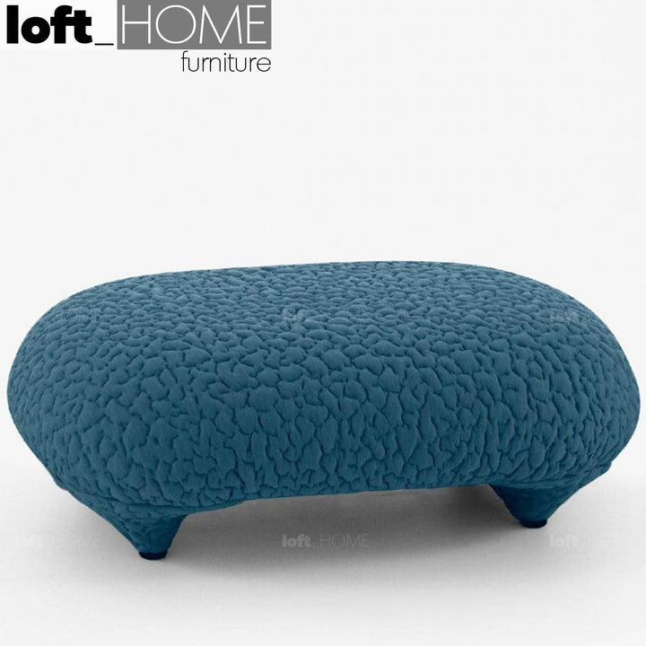 Contemporary fabric ottoman conch moby with context.