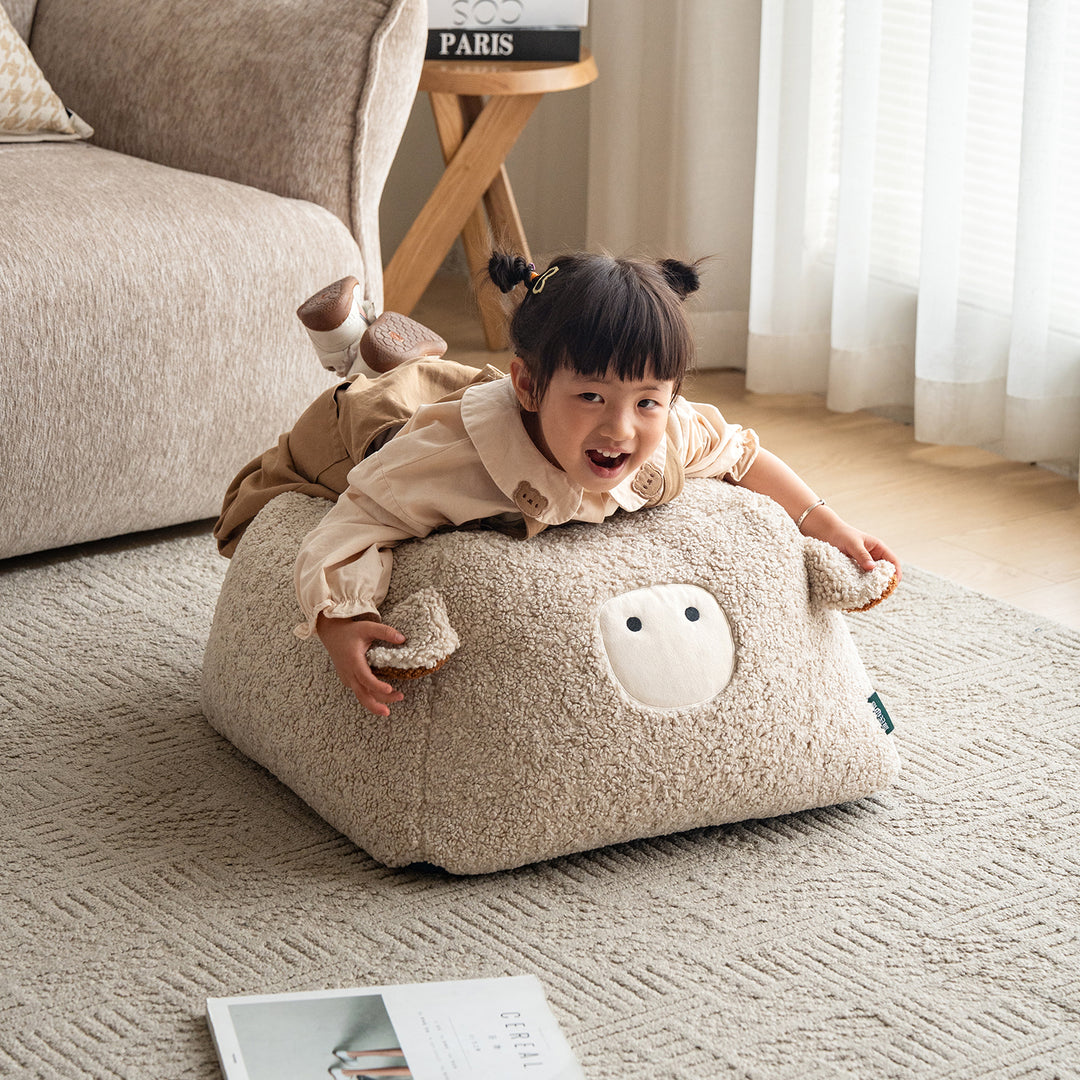 Cream boucle fabric ottoman sheep in still life.