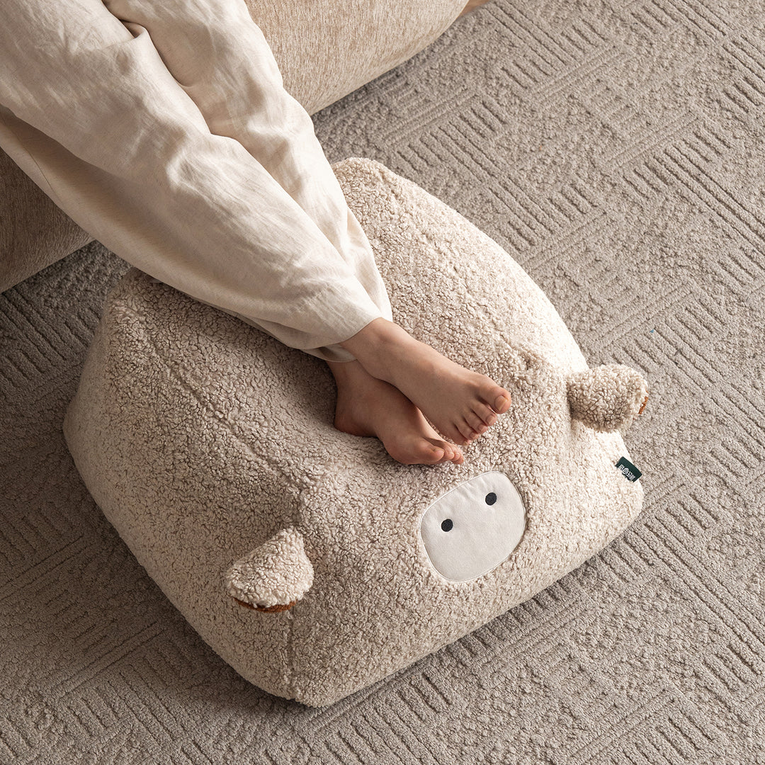 Cream boucle fabric ottoman sheep in details.