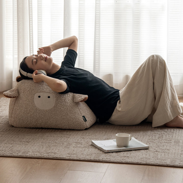 Cream boucle fabric ottoman sheep in panoramic view.