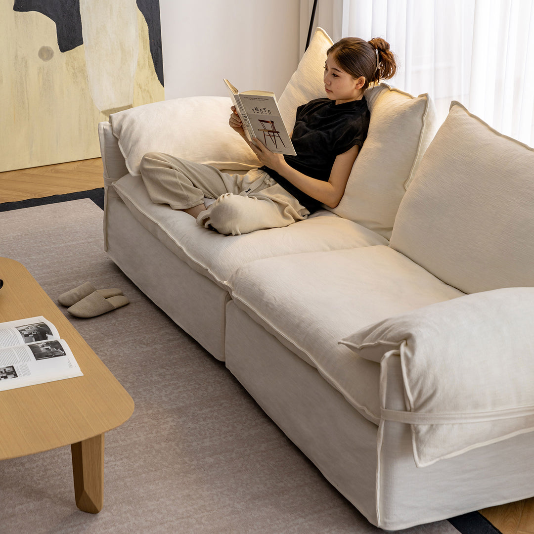 Cream cotton fabric 3 seater sofa folding ear in panoramic view.