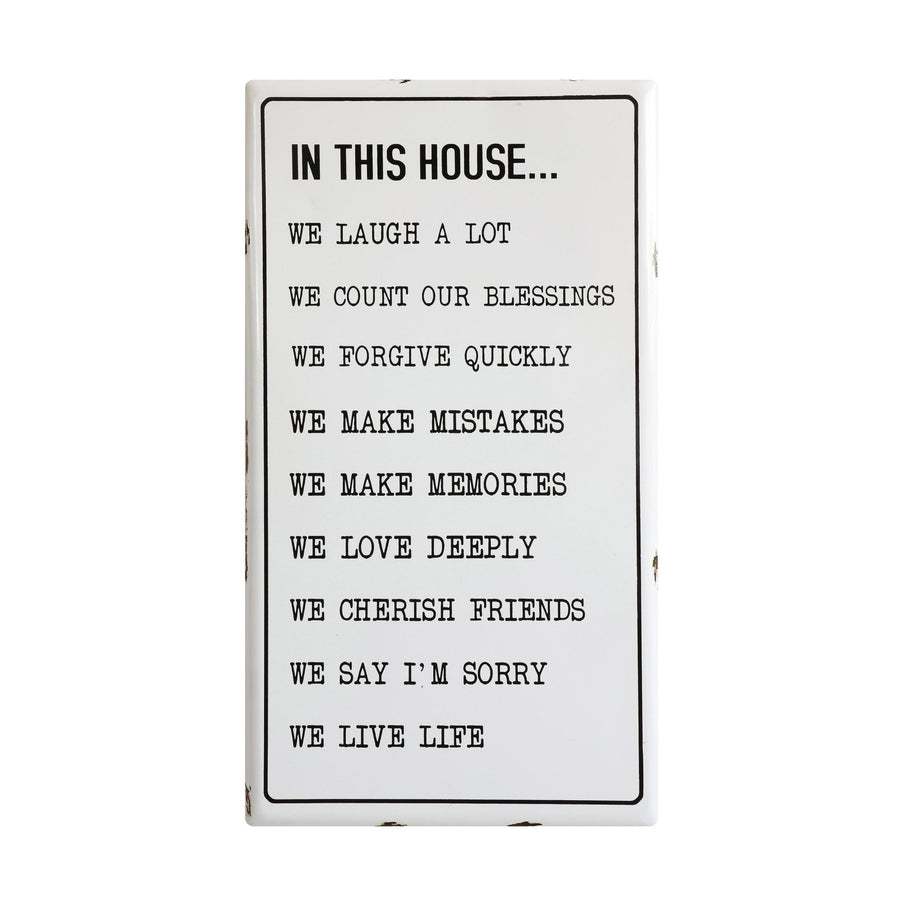 "in this house..." enameled wall plaque decor in white background.