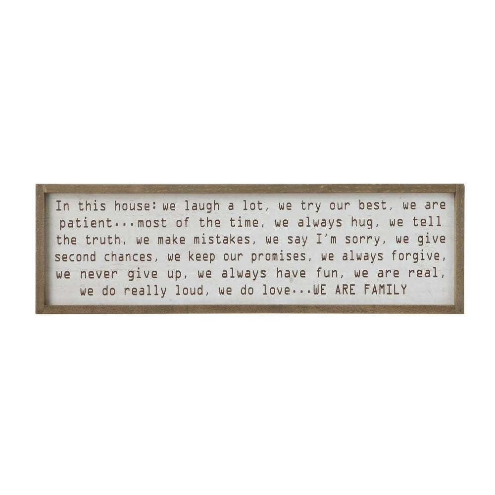 "in this house..." wood framed wall decor in white background.