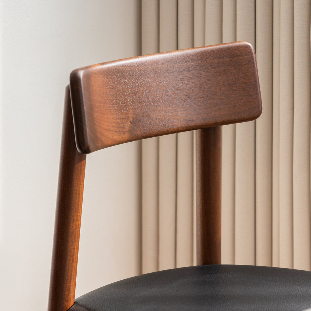 Japandi walnut wood microfiber leather dining chair green in still life.