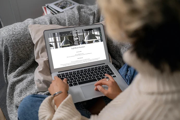 A person browsing the Loft Home Furniture FAQ page on a laptop, showcasing easy access to answers for customer inquiries.