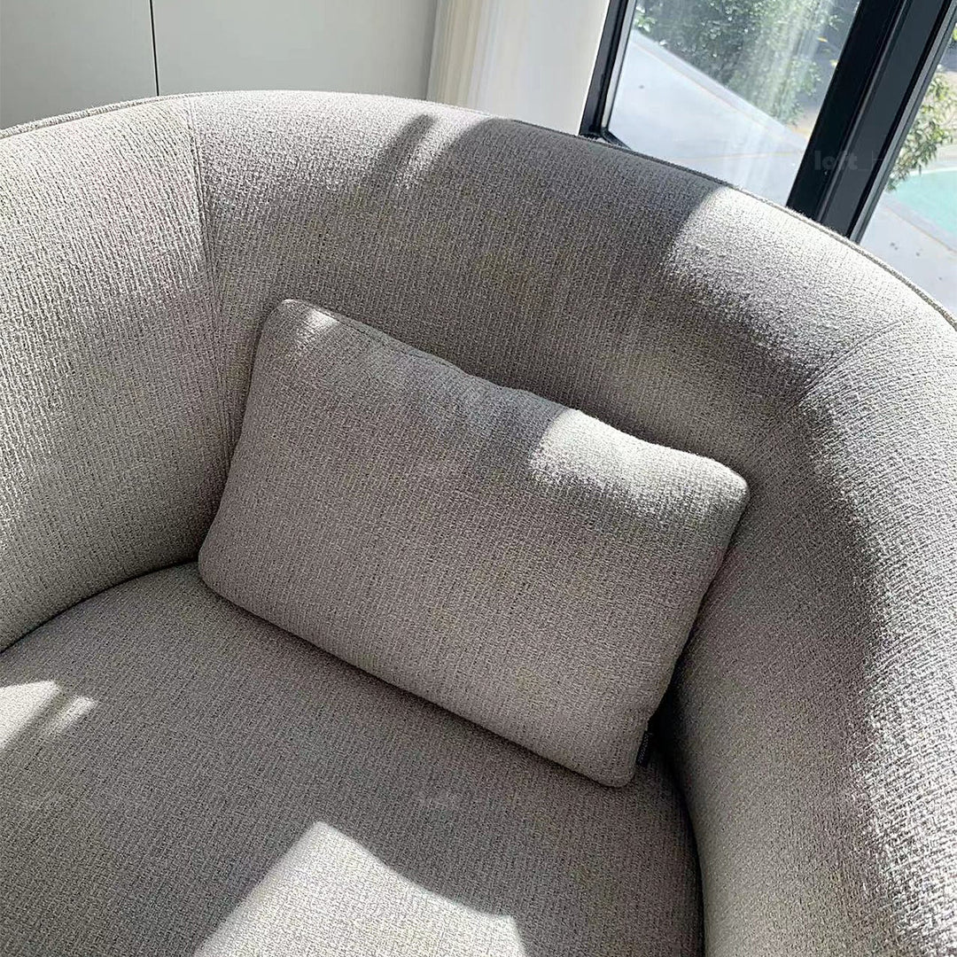 Minimalist fabric revolving 1 seater sofa heb in still life.