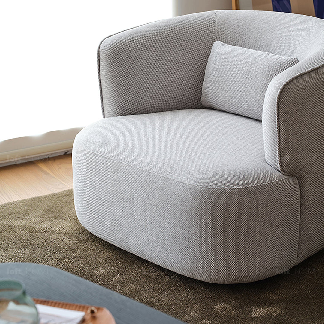 Minimalist fabric revolving 1 seater sofa heb in close up details.