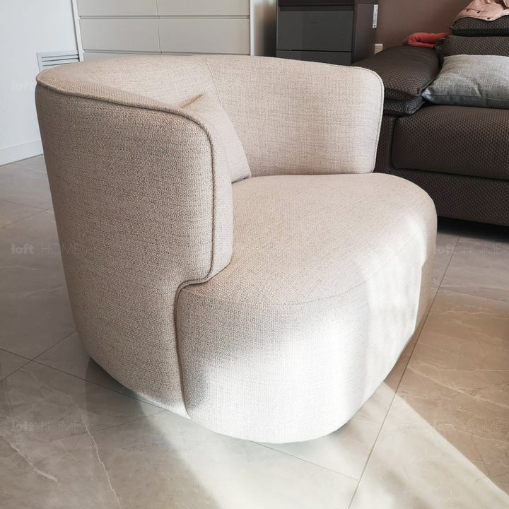 Minimalist fabric revolving 1 seater sofa heb in panoramic view.