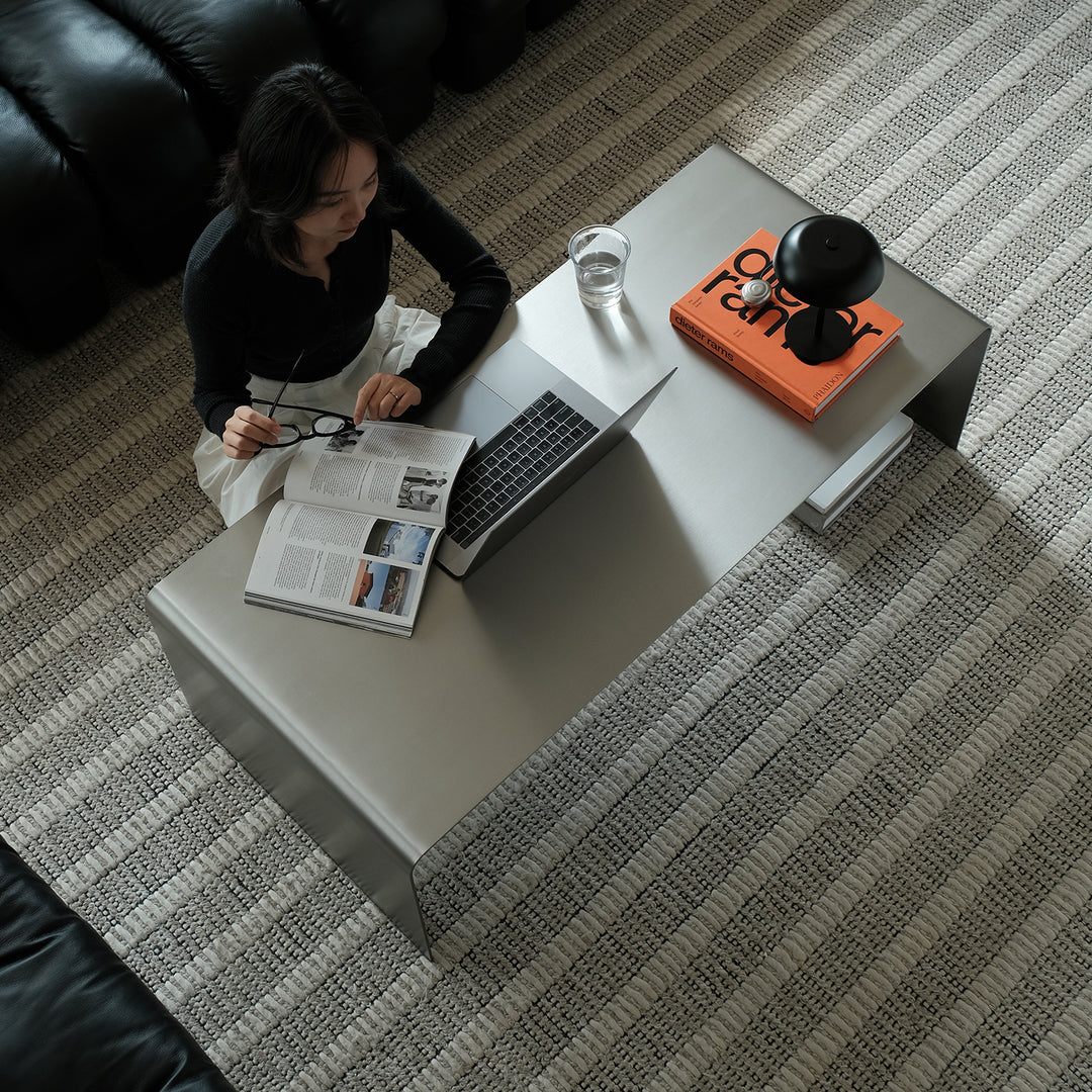 Minimalist steel coffee table arc in panoramic view.