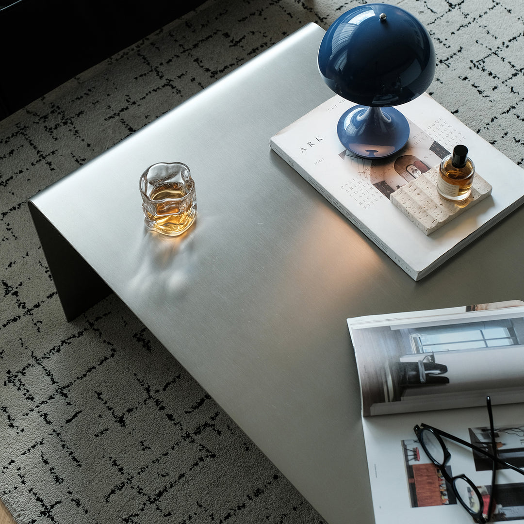 Minimalist steel coffee table arc material variants.