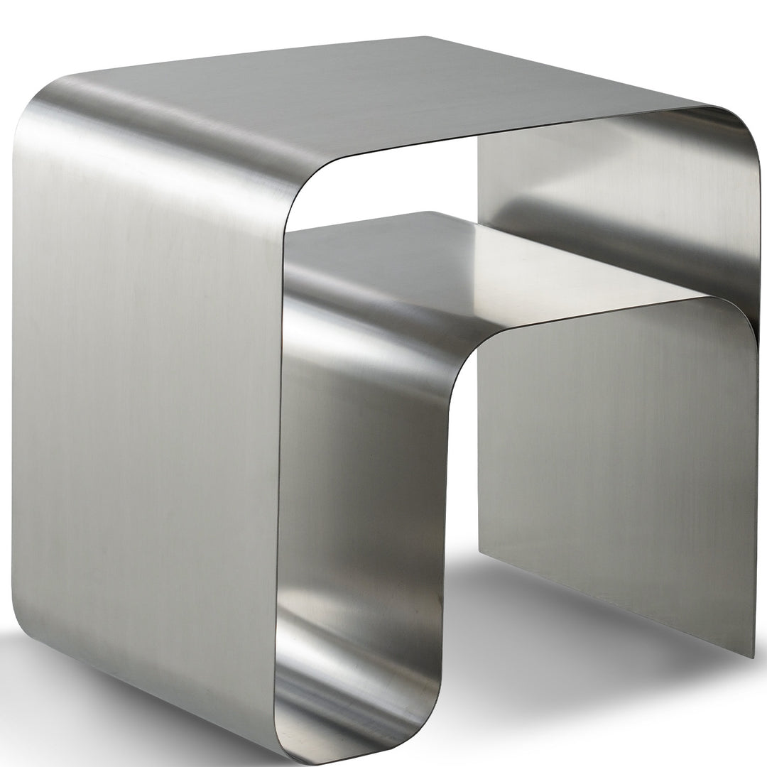 Minimalist steel side table arc in white background.