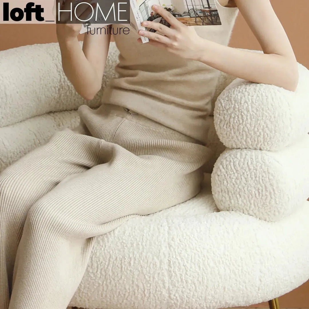 Cream fabric 1 seater sofa sheepskin in still life.