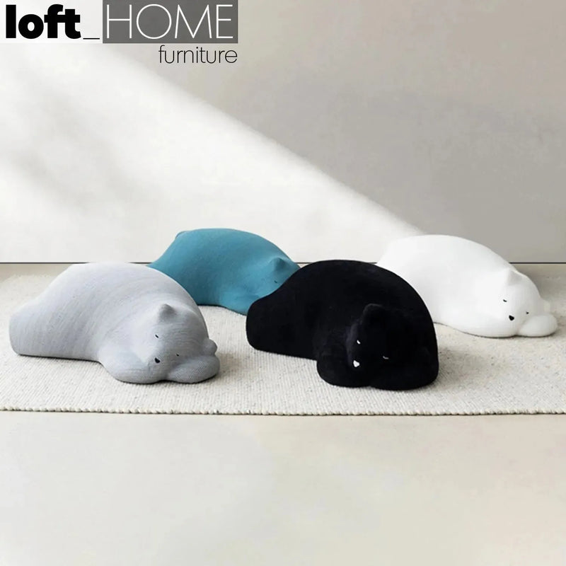 Bauhaus velvet ottoman resting bear black with context.