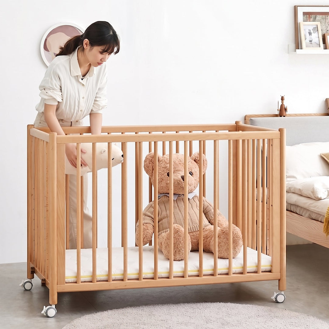 Scandinavian beech wood bed side baby crib with wheels ember primary product view.